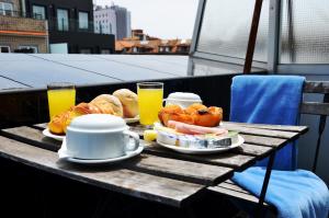 波尔图吉拉索尔酒店的阳台上的桌子上摆着早餐食品和饮料