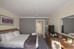 史云顿斯温顿假日酒店的配有一张床和一台平面电视的酒店客房