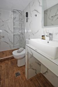 卡洛吉亚Akti Kalogria Hotel的白色的浴室设有水槽和卫生间。