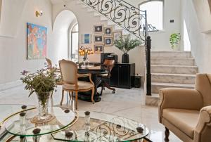 特拉维夫诺娃 - 豪华套房及精品公寓式酒店的客厅配有玻璃桌和椅子