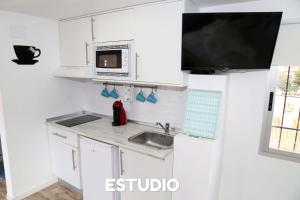 贝尼多姆Villa Ana Apartments的厨房配有白色橱柜、水槽和微波炉