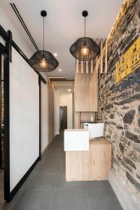 贝坦索斯Hostal Pórtico的浴室设有两盏吊灯和一堵石墙