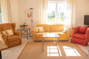 朗克维茨Familienidyll - Komfort, riesiger Garten & Badespaß的客厅配有3张沙发和1张桌子