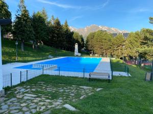 福米加尔Chalet Los Ibones - Lodge Formigal的一个带长凳的草地游泳池
