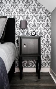 里姆斯特A Bascule Bed and Breakfast Maastricht的一间卧室配有一张床和一张带时钟的桌子