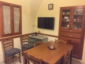 Caltabellottacasa MARINO的一间带桌椅和电视的用餐室