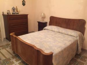 Caltabellottacasa MARINO的一间卧室配有木床和梳妆台