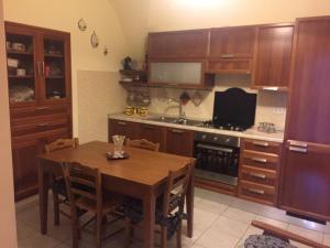 Caltabellottacasa MARINO的厨房配有木制橱柜和桌椅