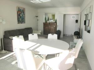 戛纳Fettolina Palm Beach, Location Cannes front de mer et plage的客厅配有白色的桌子和白色的椅子