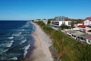 尤斯托尼莫斯基Sailor Residence的享有海滩的空中景致,设有房屋和海洋