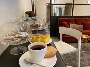 卡利亚里Suite Cagliari -99-的餐桌上放着糕点盘和咖啡