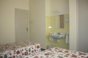 萨洛托雷玛尔旅馆的浴室设有两张床、一个水槽和镜子