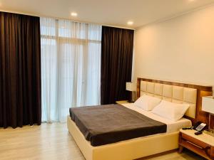 巴统Hotel Tsereteli Palace的一间卧室设有一张床和一个大窗户