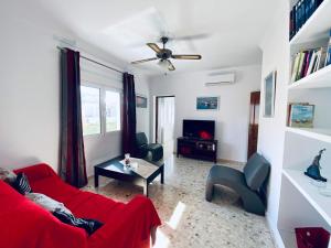 奇皮奥纳Ramón y Cajal 6的客厅配有红色沙发和电视