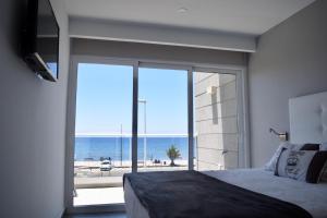 塔拉哈勒赫La Marisma的一间卧室配有一张床,享有海景