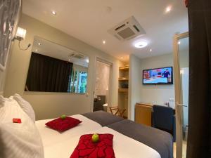 阿姆斯特丹阿尔卑斯山酒店的一间卧室配有一张带两个红色枕头的床