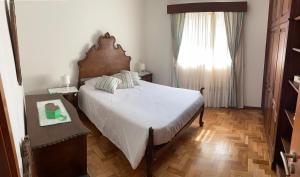 孔迪镇Casa Oliveira的一间卧室设有一张大床和一个窗户。