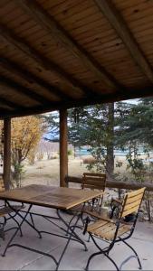 La ConsultaCasa Rural entre Bodegas y Viñedos ' El Jarillal"的屋顶下一张木餐桌和两把椅子