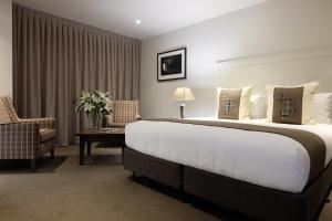 瓦纳卡瓦纳卡西草甸汽车旅馆的酒店客房带一张大床和一把椅子