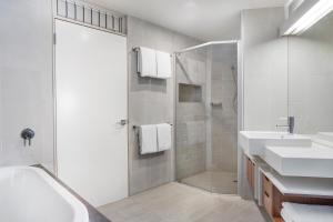 努萨角帕帕斯努萨度假村及别墅的白色的浴室设有2个盥洗盆和淋浴。