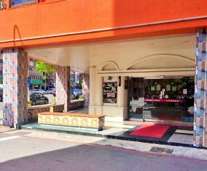 高雄Sanduo Hotel的前面的商店,前面有长凳