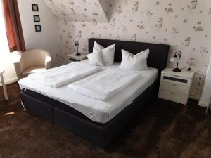 巴特萨尔茨乌夫伦Villa zur schönen Aussicht的卧室内的一张带白色床单和枕头的床