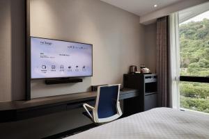 台北天阁酒店台北士林的酒店客房设有一张床和墙上的电视