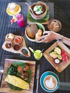图兰奔巴厘岛潜水度假及Spa酒店的一张带食物盘的桌子和一个去吃一盘食物的人