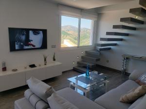 弗里希利亚纳Loft of Love的带沙发和电视的客厅以及楼梯。