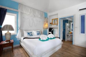象岛The White Knot Koh Chang的卧室配有白色大床和蓝色的墙壁