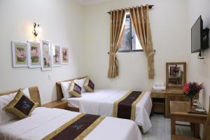 昆岛Thanh Trang Hotel的酒店客房设有两张床和电视。