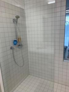 埃伦豪森Apartment am Weinberg的白色瓷砖浴室内带软管的淋浴
