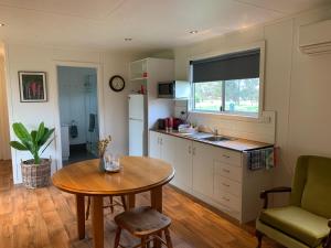 西怀厄朗Mascot Cottage - Pet Friendly and Complimentary Breakfast Hamper的厨房配有桌子、水槽和桌子