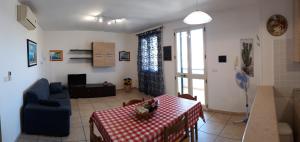 托雷圣乔万尼乌Appartamenti in villetta a Torre San Giovanni的客厅配有桌子和蓝色沙发
