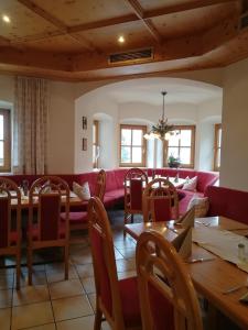 贝里斯泽尔Zur Guten Einkehr的一间设有红色沙发和桌子的用餐室