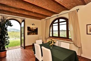 Castelnuovo della MisericordiaAgriturismo Scaforno Vacanze的一间带绿色桌椅的用餐室