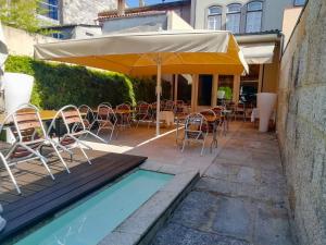布拉加布拉卡拉奥古斯塔酒店的一个带椅子和遮阳伞的庭院和一个游泳池