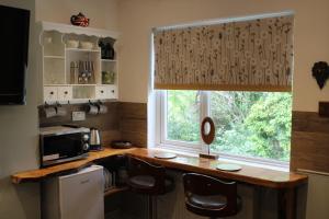 格拉斯顿伯里海顿之家旅馆的厨房设有窗户和带椅子的柜台。