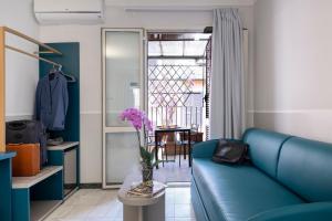 罗马德里佛酒店的客厅配有蓝色的沙发和花瓶