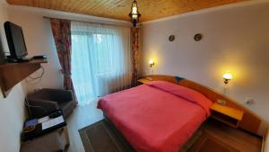 珀尔蒂尼什Casa de vacanta Two Brothers Concept的一间设有红色床和电视的小卧室