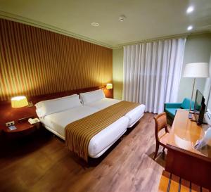 昆卡托雷曼加纳酒店的酒店客房设有一张大床和一张书桌。