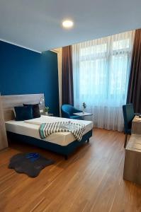 埃森New Work Hotel Essen的一间卧室设有一张大床和蓝色的墙壁