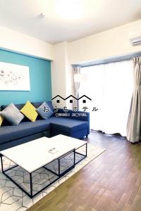 广岛OUCHI HOTEL Dambara的客厅配有蓝色的沙发和茶几