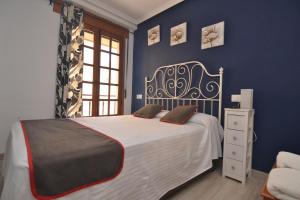 阿雷纳斯德圣佩德罗Hostería El Bodegón De Gredos的一间卧室配有一张带蓝色墙壁的大床