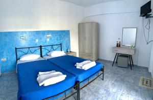 普拉索尼西Kedros Rooms的蓝色卧室配有蓝色的床和白色枕头