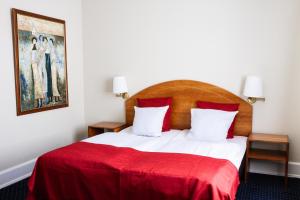 哥本哈根尼波城市酒店的一间卧室配有一张带红色毯子的床