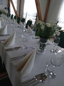 GrochówGrochowiak的一张带白色餐巾和花瓶的桌子