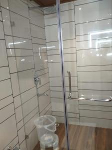 ForbesganjHotel Jyoti的浴室设有玻璃淋浴间和玻璃门