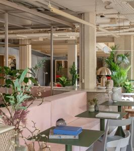 伦敦Locke at Broken Wharf的一间设有桌椅的餐厅,种植了植物