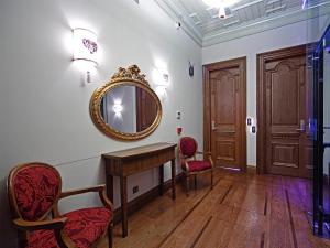 伊斯坦布尔席琳酒店 - 奥斯曼大厦的一间设有镜子、一张桌子和椅子的客房